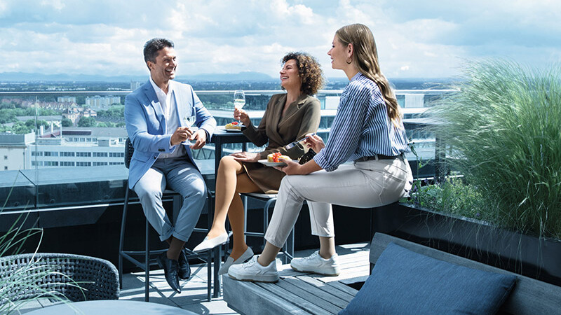 A man and two women wearing compression stockings are on a roof terrace A man and two women wearing compression stockings are on a roof terrace