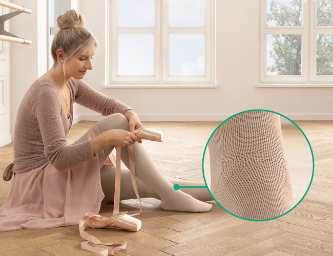 funktionszone vrist Kvinde i ballerinaoutfit med Juzo Expert med funktionszone vrist sidder på gulvet og tager tåspidssko på