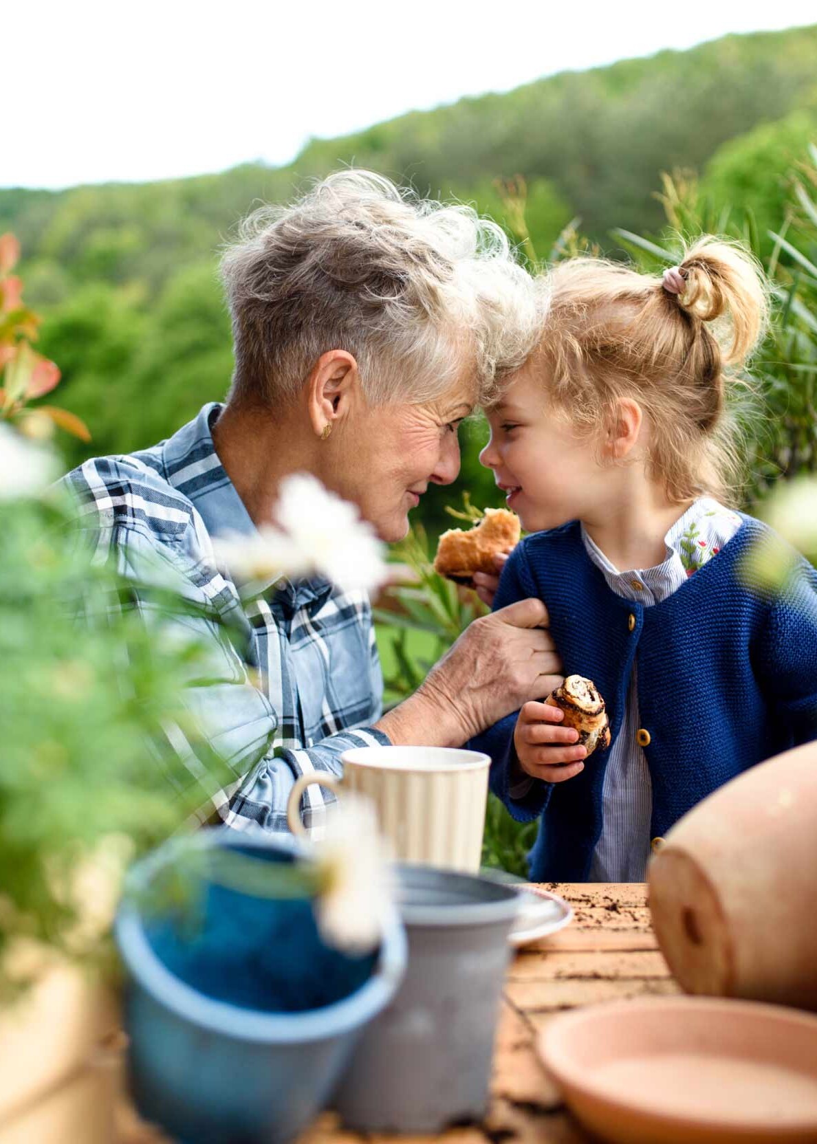 Die Zeit im Garten sicher gemeinsam genießen Eine Oma sitzt mit ihrer Enkeltochter im Garten