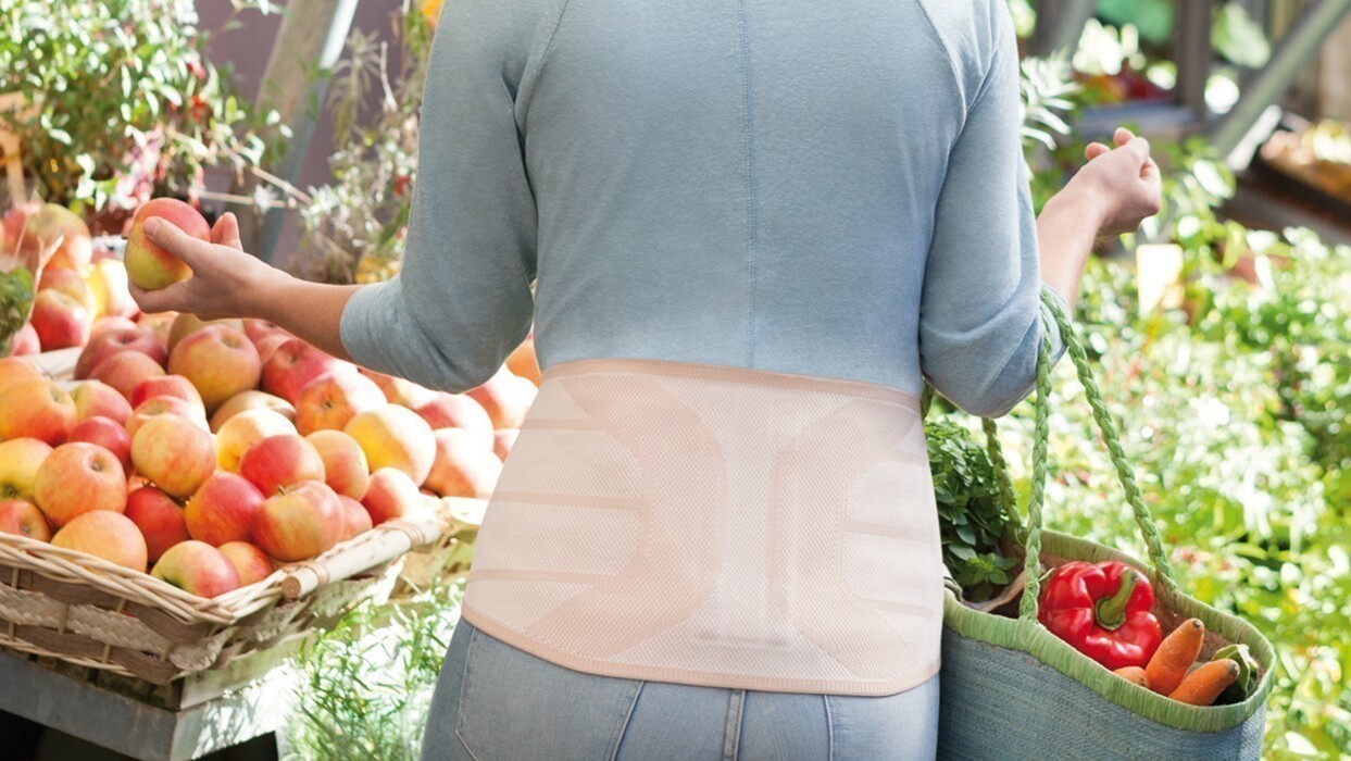 Woman in a supermarket wearing a back brace