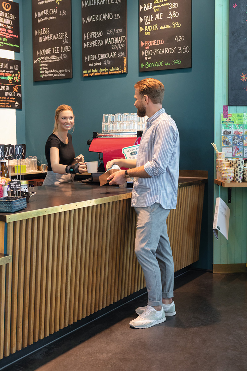 Kellnerin in einem Cafe trägt eine Handgelenkbandage Kellnerin in einem Cafe trägt eine Handgelenkbandage